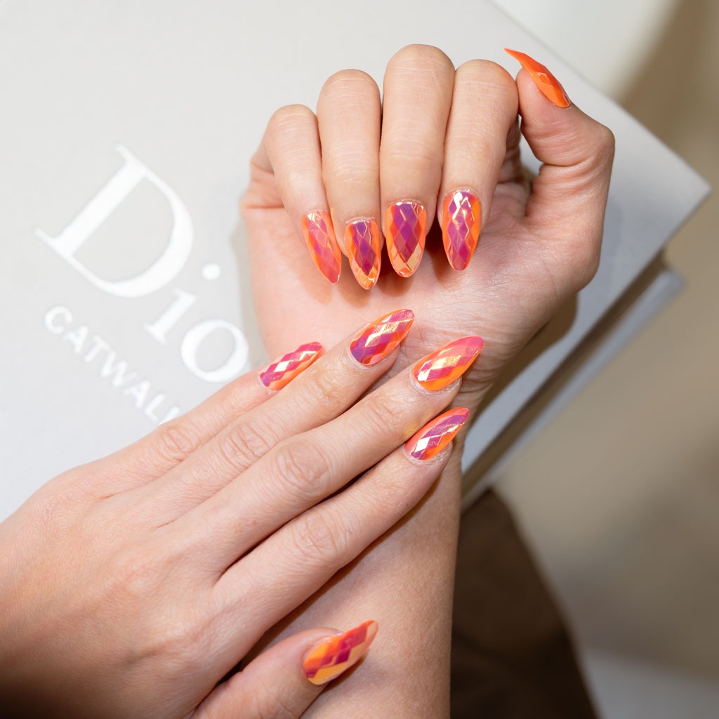 Orange geometric nail art at H’ONU with glossy finish and bold patterned design on almond nails