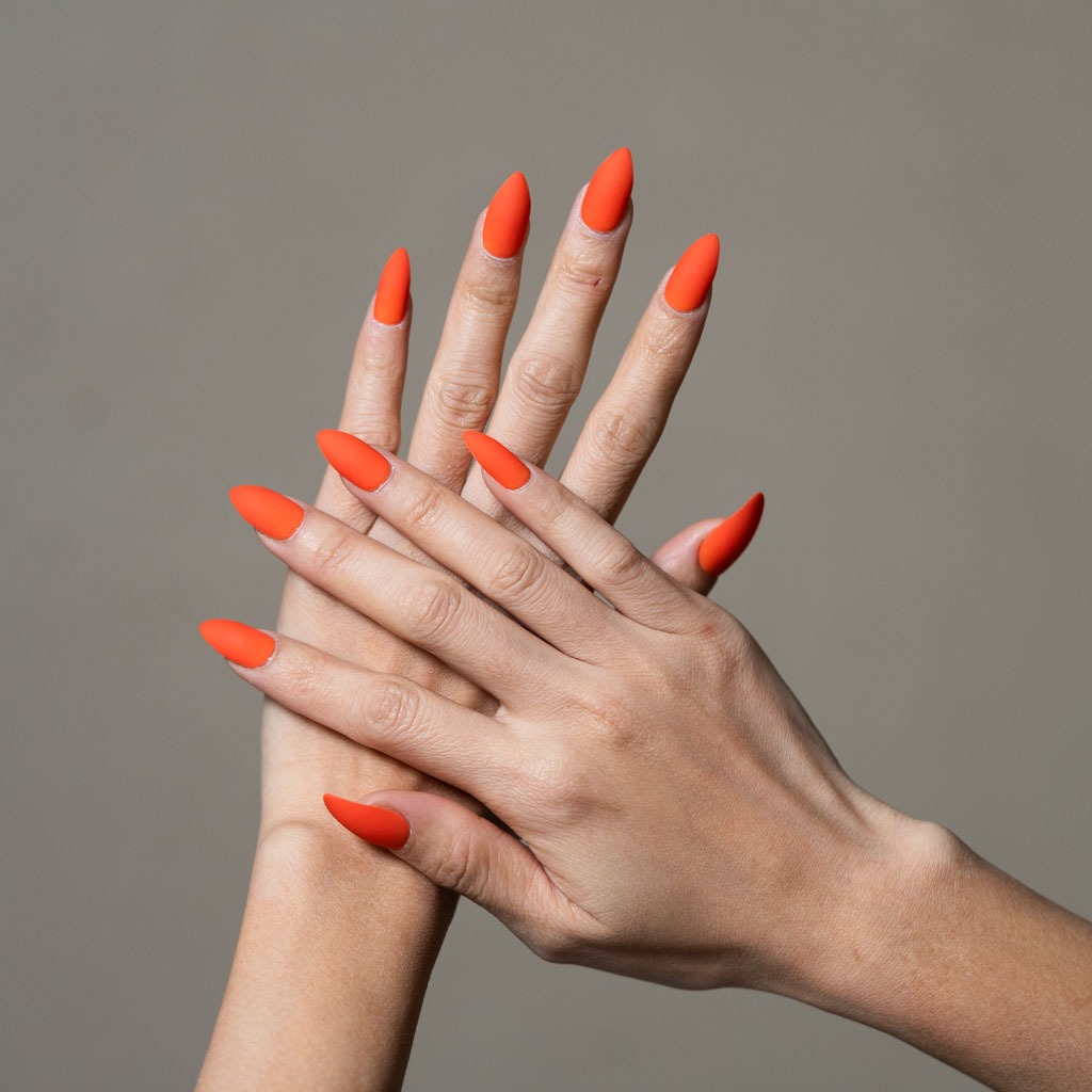 Bright orange gel nails at H’ONU with almond shape and bold smooth finish for a modern nail look