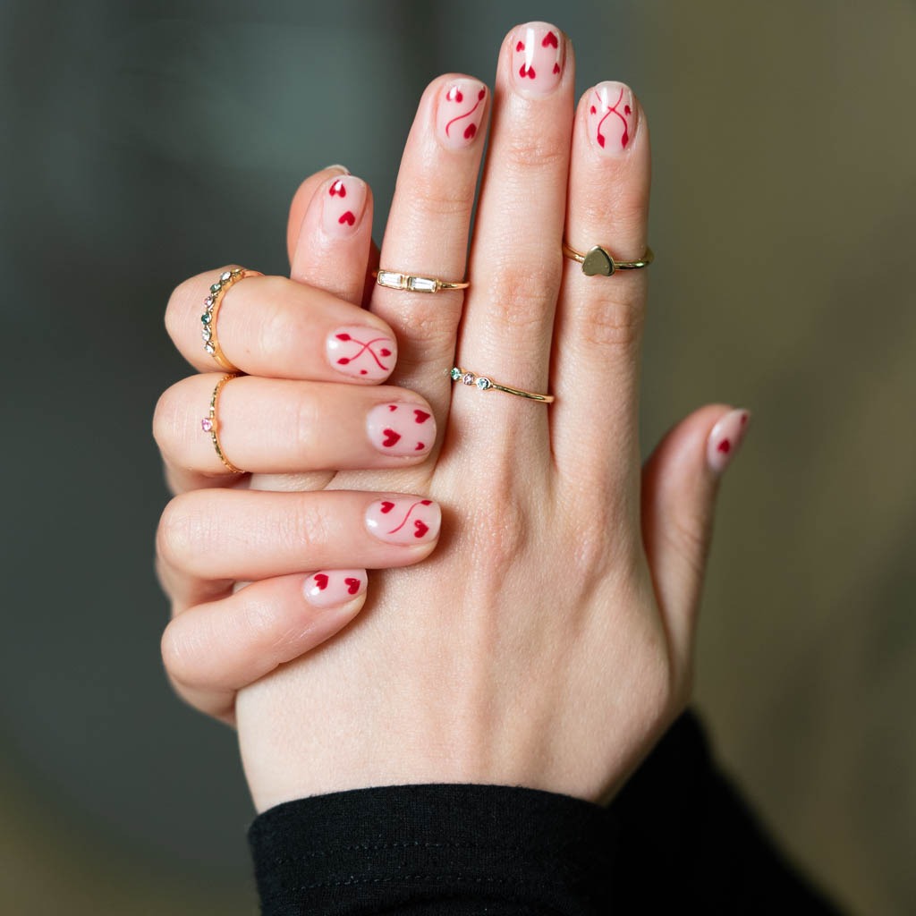 Minimal heart nail art at H’ONU with nude base and small red heart design for a clean playful look